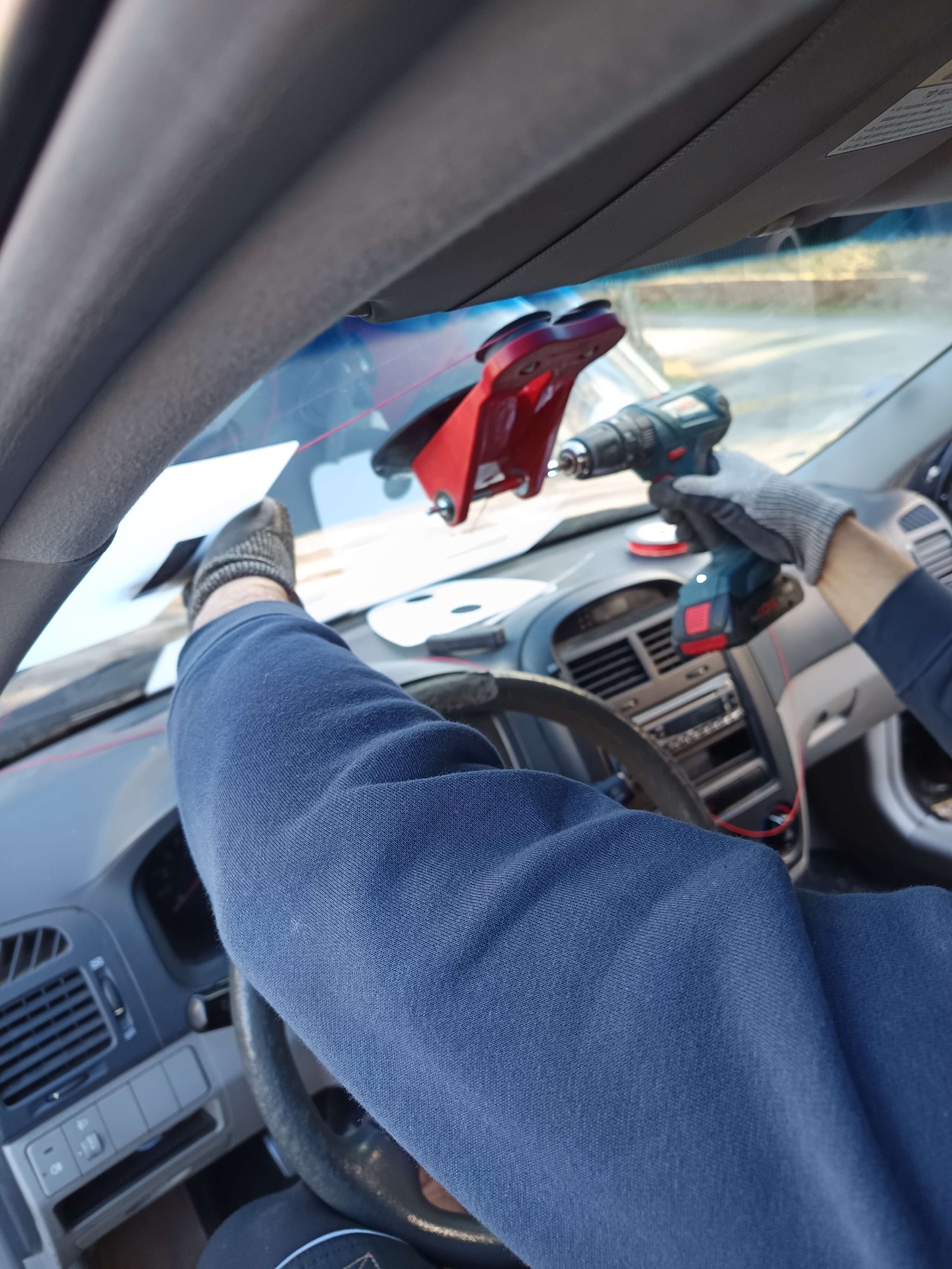 Découpe du pare-brise au fil depuis l'intérieur du véhicule